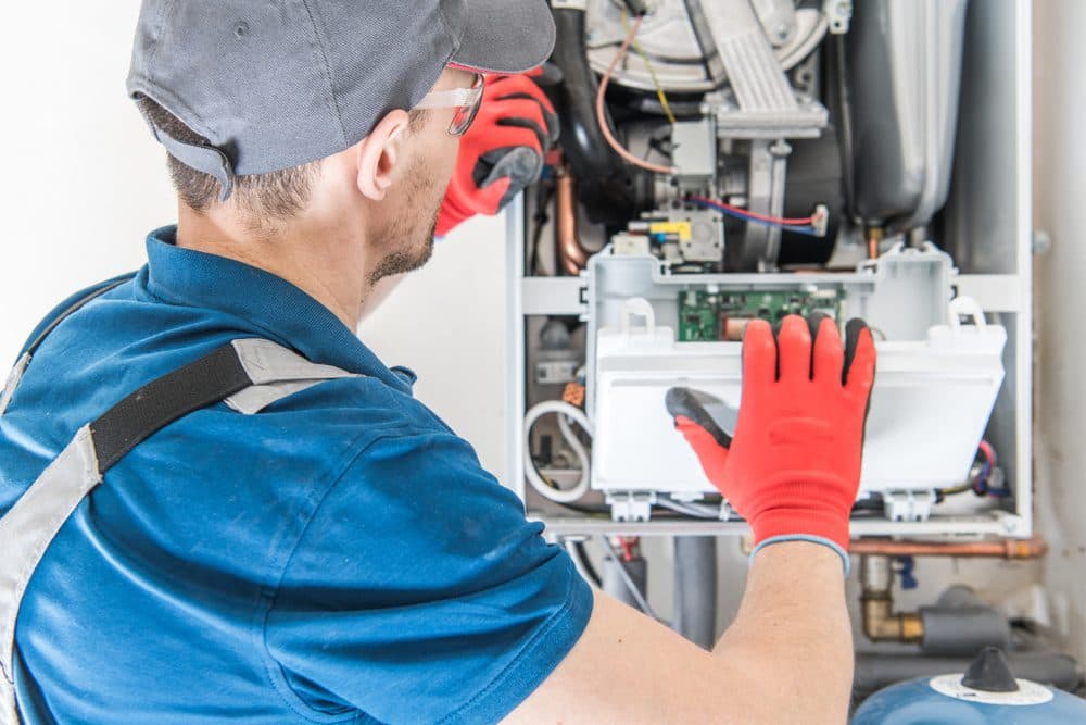 A Casteel technician performing a repair on the inside of a furnace