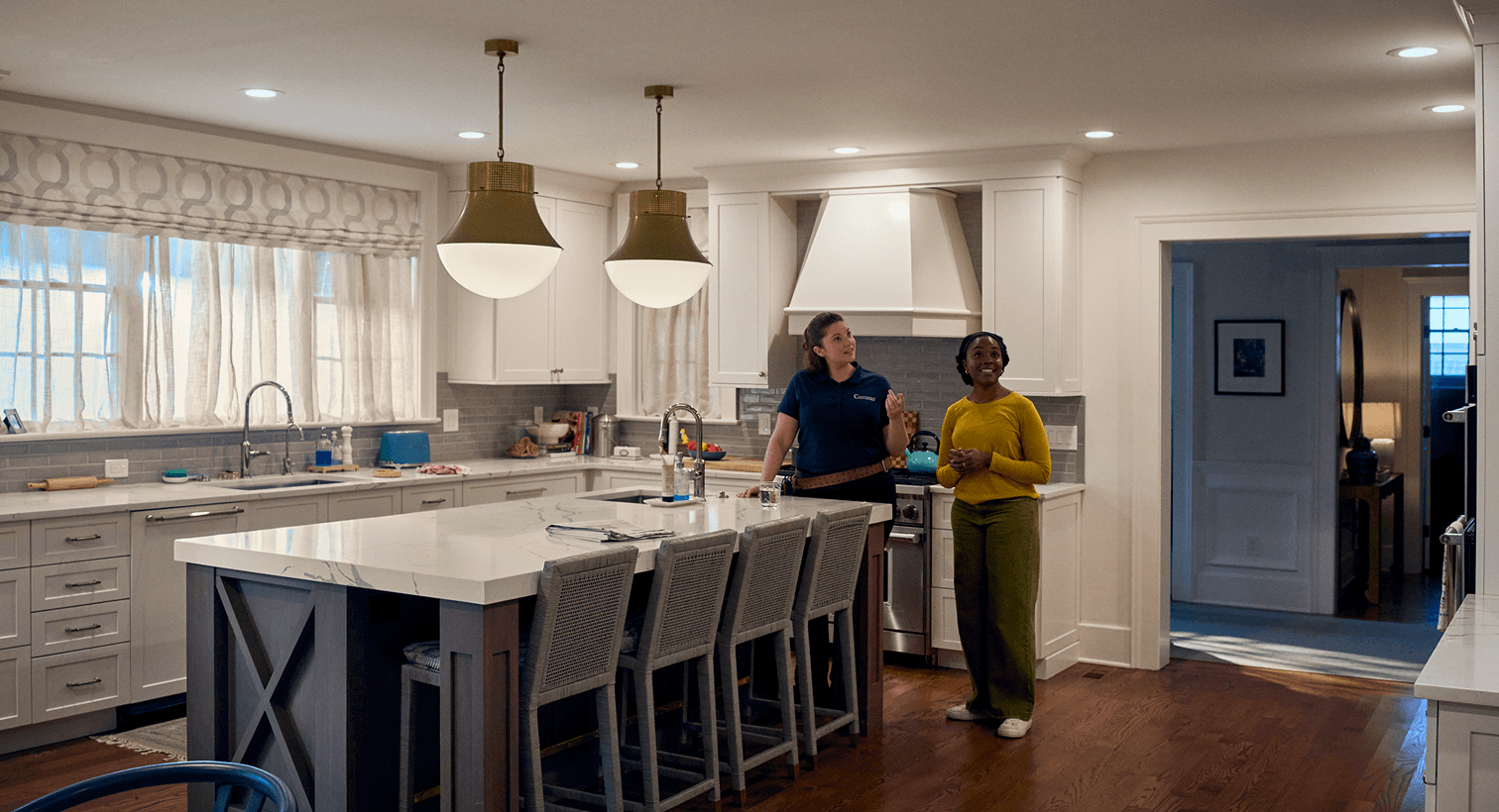A homeowner and a Casteel technician talk in her dining room