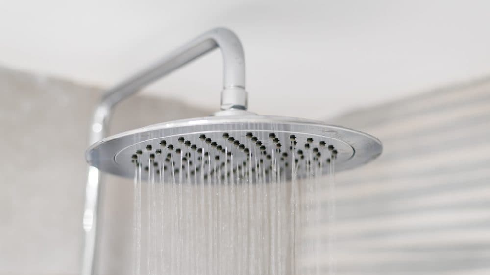 A circular rain showerhead dumping water downwards