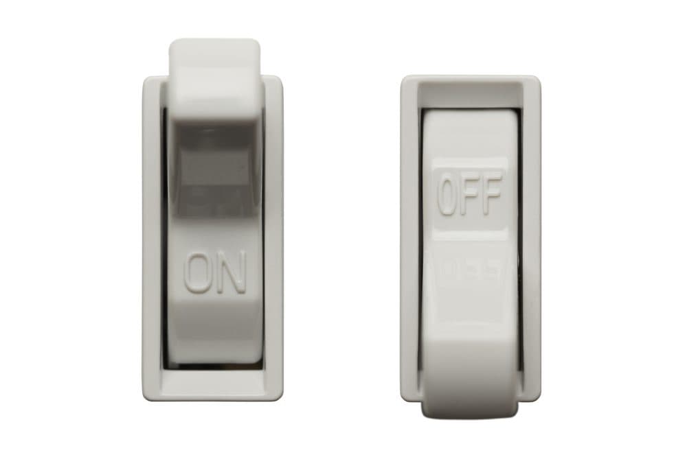 Two light switches with the left being on and the right being off