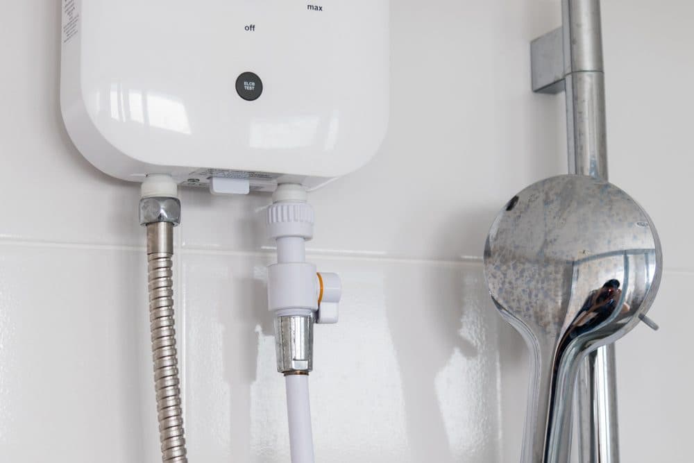 Tankless water heater installed on white subway tile