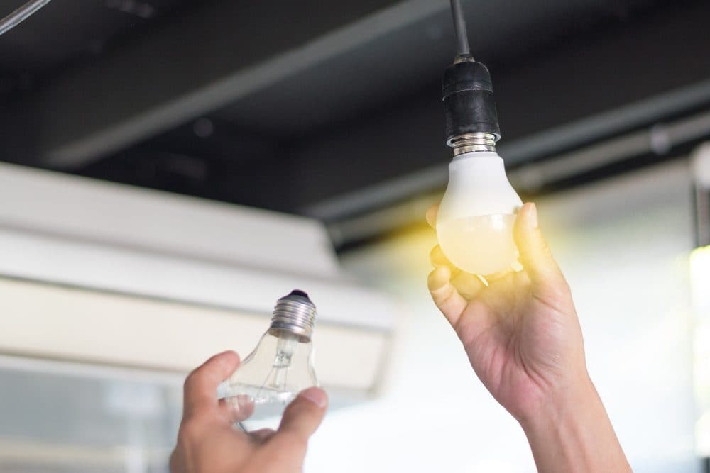 Changing lightbulbs with the one in the socket turned on and the other one is just in a person's left hand