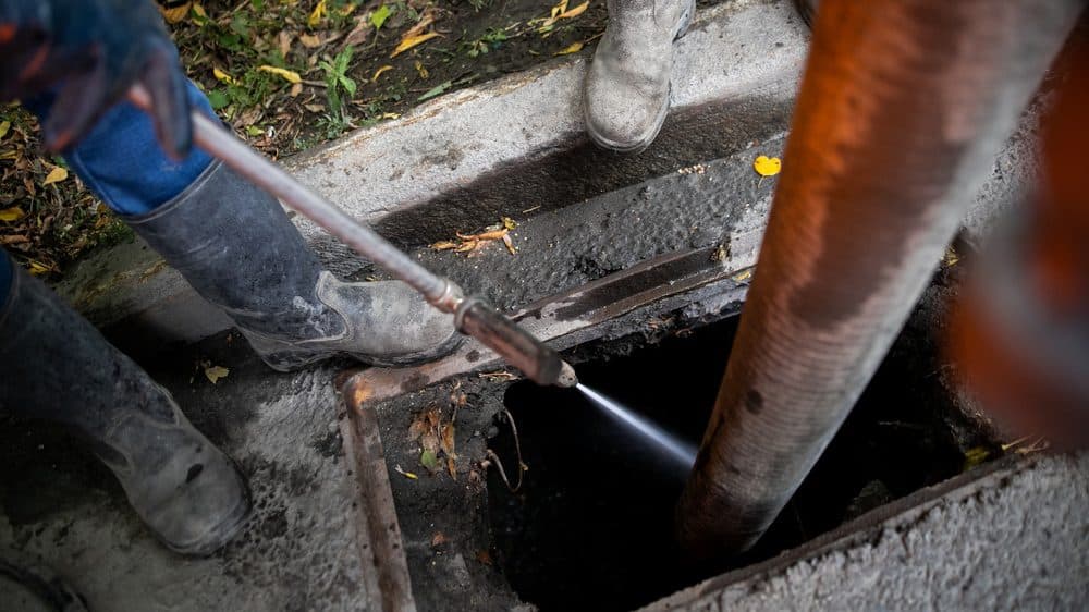 A Casteel technician using hydro jetting to clean clogged pipes