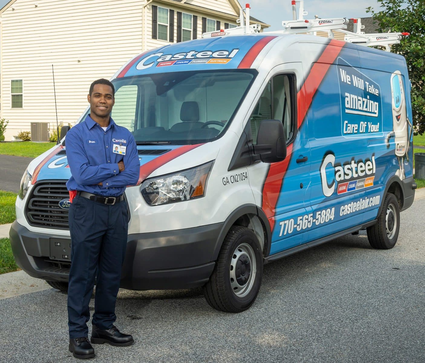 A Casteel technician smiling in front of his van