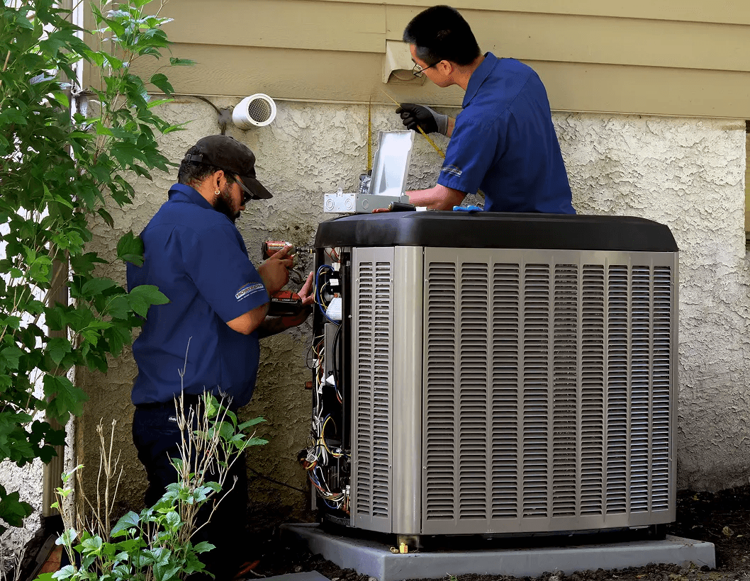 Two technicians working on replacing an AC