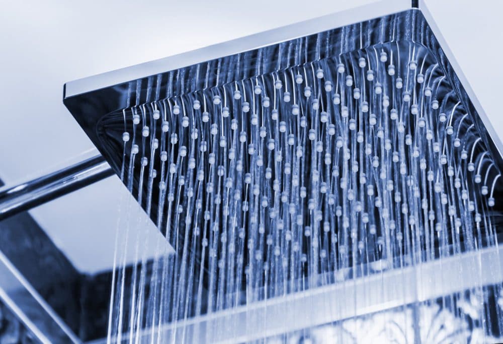A square rain shower head streaming water downwards