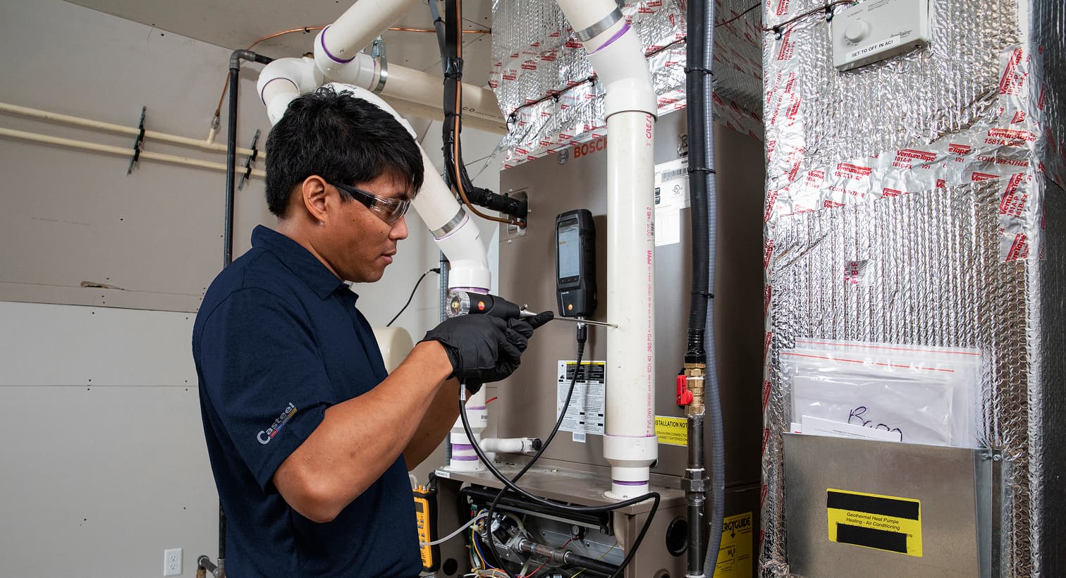 A Casteel technician working on a heating and cooling system