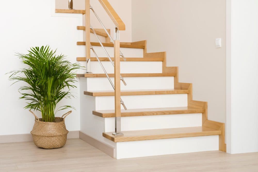 A staircase with wood stairs and white backing boards