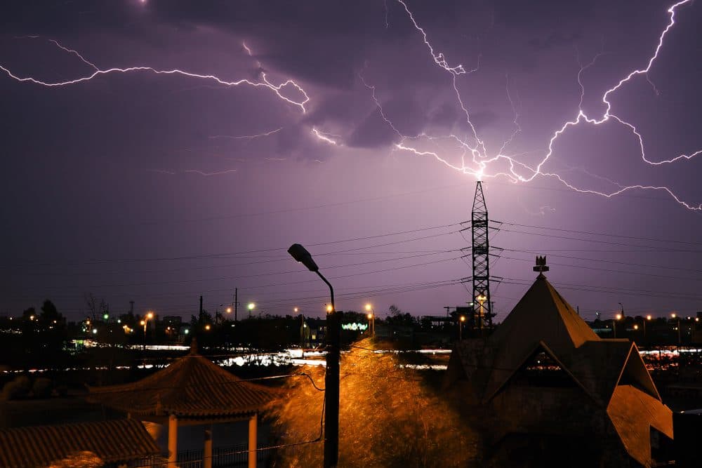 A lightning strike hitting a large tower in a city setting