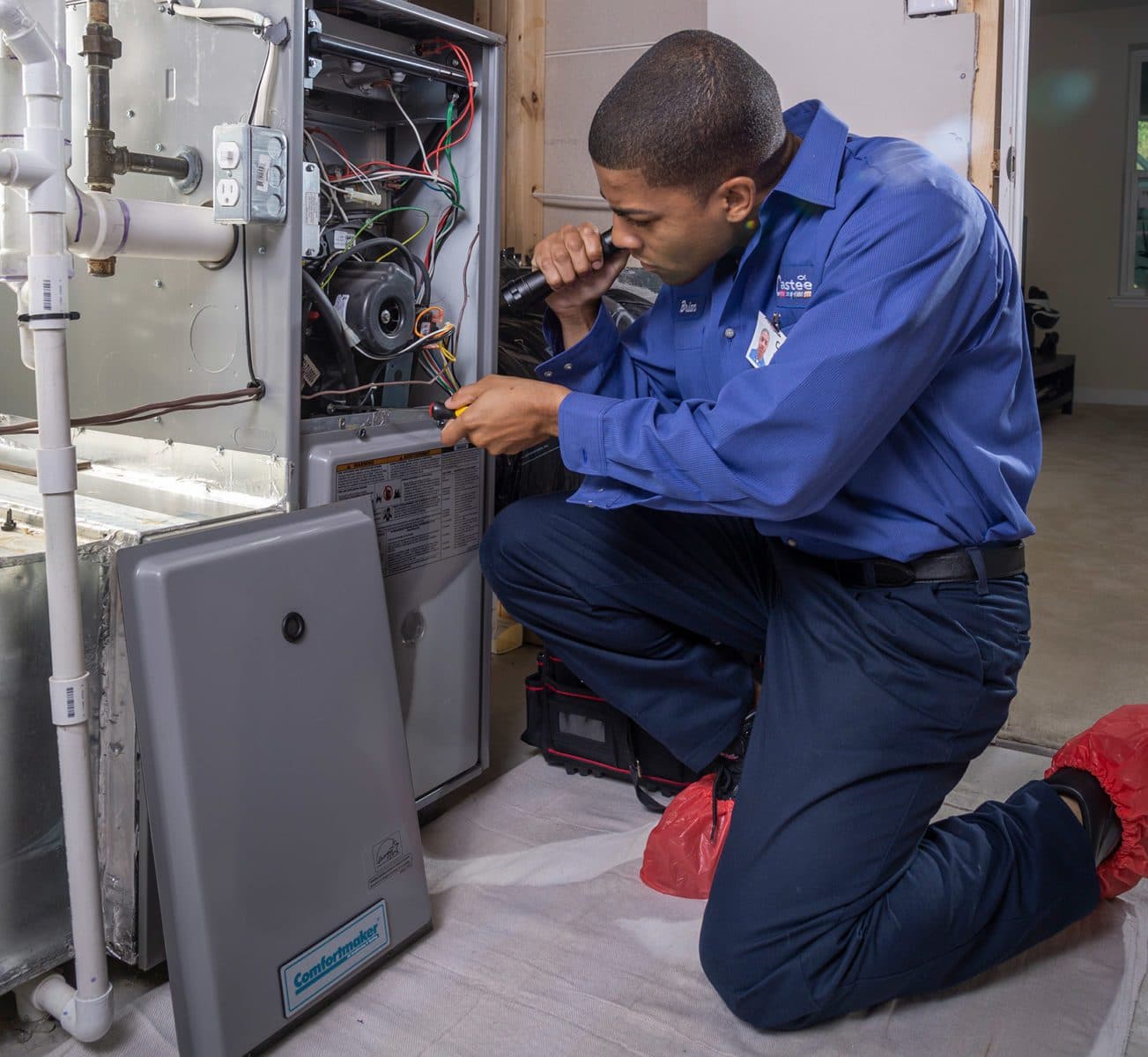 A Casteel technician looking into an opened HVAC unit