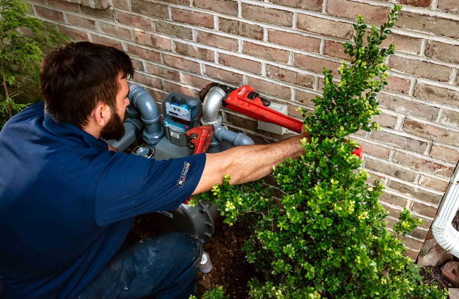 A Casteel technician working on a home’s exterior gas line